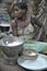 Jungle of CAR. Africa. Jungle of the Central-African Republic. Baka woman cooks food, crushing a flour in a mortar