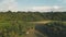 Jungle at tropic countryside aerial panorama shot. Small wooden farm buildings, houses on rice field