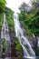 Jungle waterfall cascade in tropical rainforest with rock and turquoise blue pond. Its name Banyumala because its twin waterfall