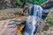 Jungle waterfall with flowing water, large rocks