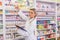 Junior pharmacist taking medicine from shelf