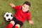 Junior soccer player sitting on a green field