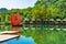 Junk. Beautiful traditional vietnamese boat with red sails on a picturesque lake in the jungle. Many small houses are reflected in