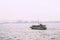 Junk boat sailing across rainy halong bay vietnam with land in the background