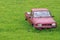 Junk car abandoned on a meadow