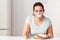 Junk Food. Chubby girl taped with patch mouth sitting at kitchen table with desserts looking camera concerned