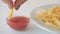 Junk food french fries tomato sauce hand dipping