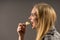 Junk food and unhealthy eating concept. Portrait of young woman who holding fried potato chips at the mouth