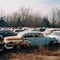 Junkyard of old cars, many different broken rusty cars,
