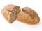 Just baked loaf of rye bread cut in two pieces. On white background