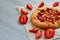 Just baked strawberry tart on the gray concrete background with copy space. Vegetarian healthy rhubarb galette