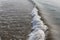 Just breaking ocean wave in blue and brown water, high angle view