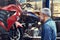 He just couldnt walk by without a peek. a mature man admiring the window display of a motorcycle shop.