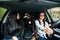 Just keep driving. Three beautiful young cheerful women looking away with smile while sitting in car