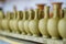 Just made pottery in clay workshop. Row of handmade jugs, selective focus