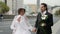 just married couple in big city, bride in white dress and groom in black suit
