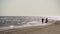 Just married couple holding hands, running at the sandy sea shore at wedding photoshoot. Happy bride with bouquet and