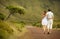 Just married couple in honneymoon walking along countriside road on Flores island, Azores