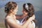 Just married happy lesbian couple in white dress near small lake