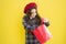 Just a minute of surprise. Little girl looking for surprise gift on yellow background. Small child holding shopping bag