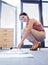 She just needed a change of perspective. an attractive young woman crouched in front of papers lined up on the floor.