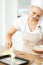 Just one spoonful is enough...Lovely young woman baking biscuits in her kitchen at home.