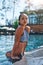 Just perfect. Gorgeous young woman in swimwear looking at camera while getting out of the swimming pool