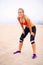 Just a quick breath before another 10k. Portrait of a young woman taking a breather while jogging at the beach.