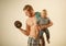 Just sport. Strong man with dumbbells hold baby boy. Father build biceps triceps with son. Father and child training