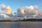 Just after sunrise a group of geese flies out of the water of lake Zoetermeerse Plas with colorful majestic clouds in the backgrou