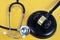 Justice and health concept with a stethoscope and a judge`s gavel close up on a yellow background
