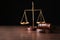 Justice scales and judges gavel on table against black background