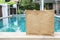 Jute tote grocery shopping bag on swimming edge over blurred garden and house background