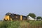 K&O Train hauling Electric Windmill blades with tree`s and blue sky out in the country.