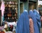 Kabul, Afghanistan: Afghan women wearing blue burqas standing outside a shoe store