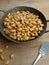 Kacang bawang or garlic flavored fried peanuts placed in a frying pan isolated on wooden board background. Closeup photo.