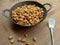 Kacang bawang or garlic flavored fried peanuts placed in a frying pan isolated on wooden board background. Closeup photo.