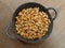 Kacang bawang or garlic flavored fried peanuts placed in a frying pan isolated on wooden board background. Closeup photo.