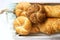 Kaiser wheat and rye flour buns with seeds, mini baguettes with ham and cheese, fresh bread. Selective focus