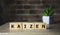 Kaizen improvement sign made of blocks on a wooden desk in a bright room