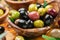 Kalamata, green and black olives in the wooden bowl. Food background