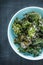 Kale chips with salt in pastel blue bowl from above