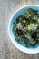 Kale chips with salt in pastel blue bowl captured from above (top view)