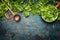 Kale in cooking pot with wooden spoon on rustic background, top view, border.