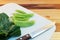 Kale, peas, knife rests on the plastic cutting board.