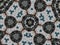 Kaleidoscope pattern with polygon and flower-shaped figures in gray and brown