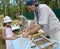 KALININGRAD REGION, RUSSIA. The master shows to the girl how to make a frame for bee sot. A festival of honey on Curonian Spit