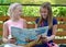 KALININGRAD, RUSSIA. Cheerful girls girlfriends discuss the book on a bench. The Russian text - Gulliver`s Travels