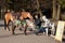 KALININGRAD, RUSSIA - MARCH 29, 2014: Unknown young people sit on chairs near a saddled horse and a little pony.