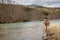 Kalum River, British Columbia, Canada - April 11th, 2017: A fly fisherman hooked into a big fish in a river with the rod bent